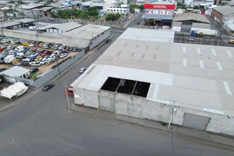 Vista aérea de un galpón industrial de gran cubierta en una esquina urbana